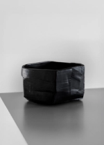 A low, black vase by ceramic artist Meneguzzo