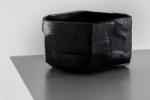 A low, black vase by ceramic artists Meneguzzo