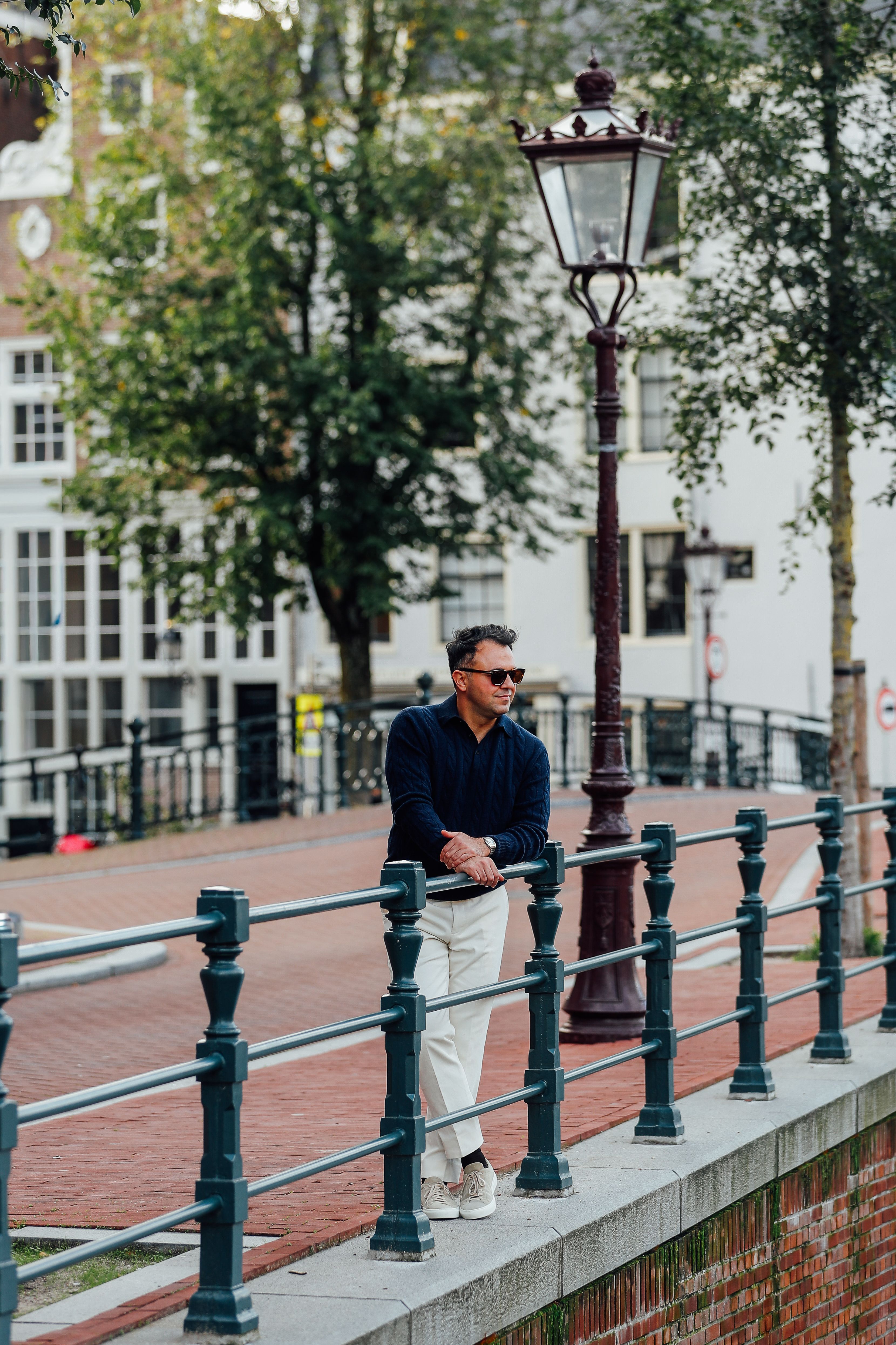 The Rover outfit met cashmere polo, witte pantalon en beige sneakers