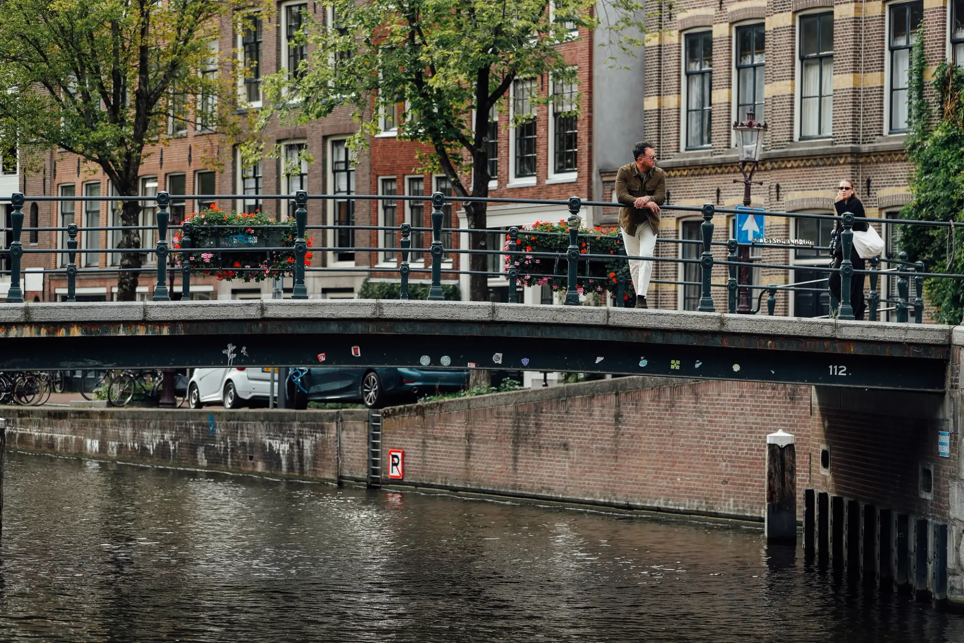 Amir kijkt over brug in Amsterdam
