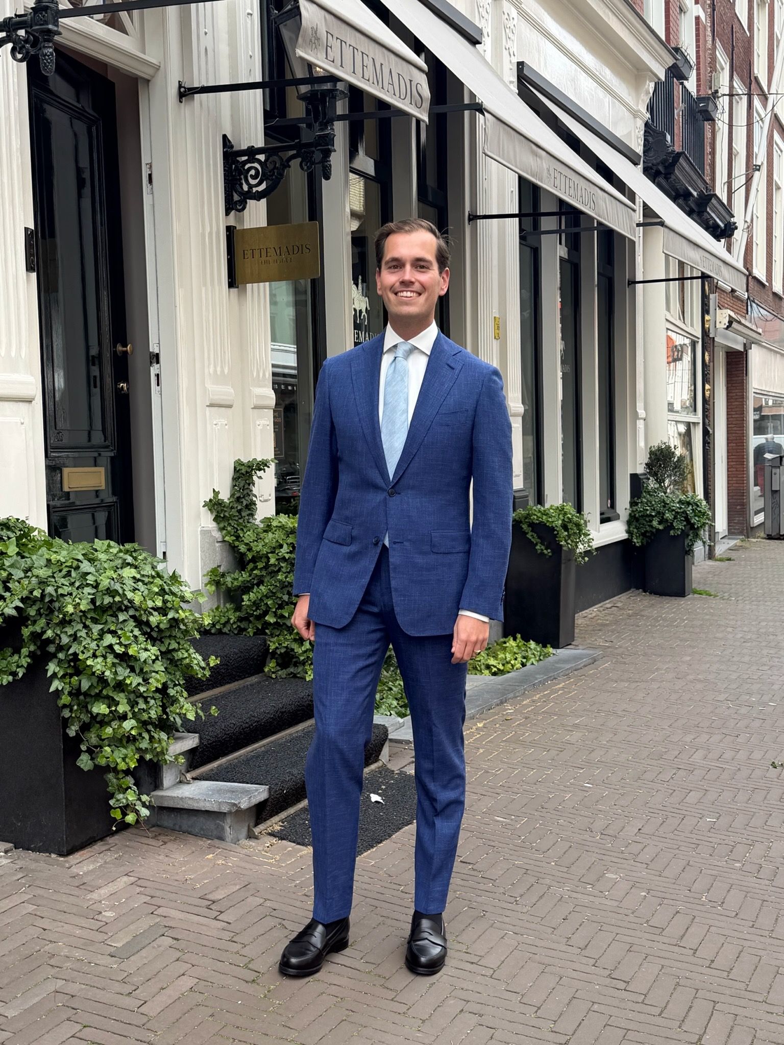 Klant draagt grijs-blauw driedelig trouwpak bij Ettemadis