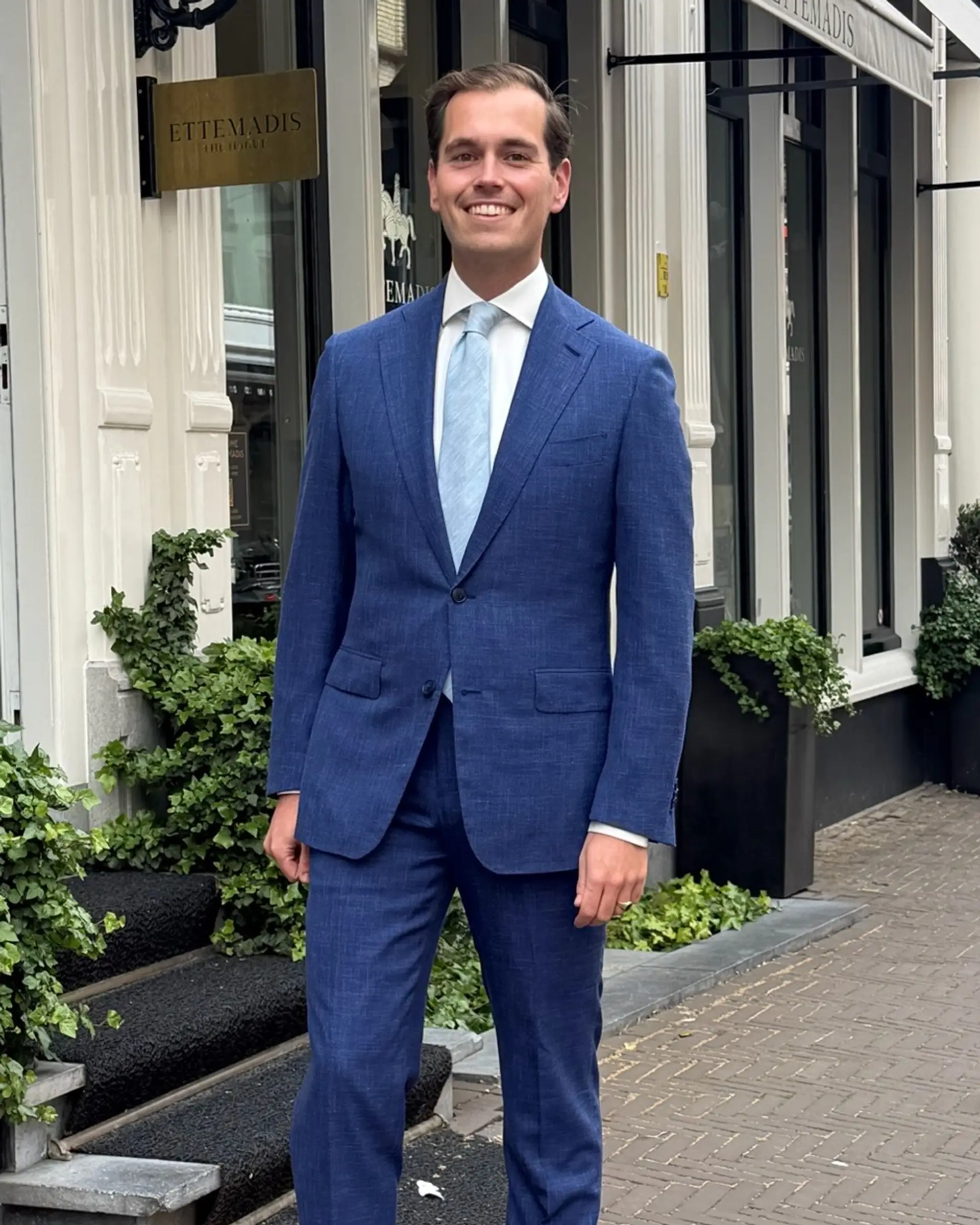 Klant draagt grijs-blauw driedelig trouwpak bij Ettemadis