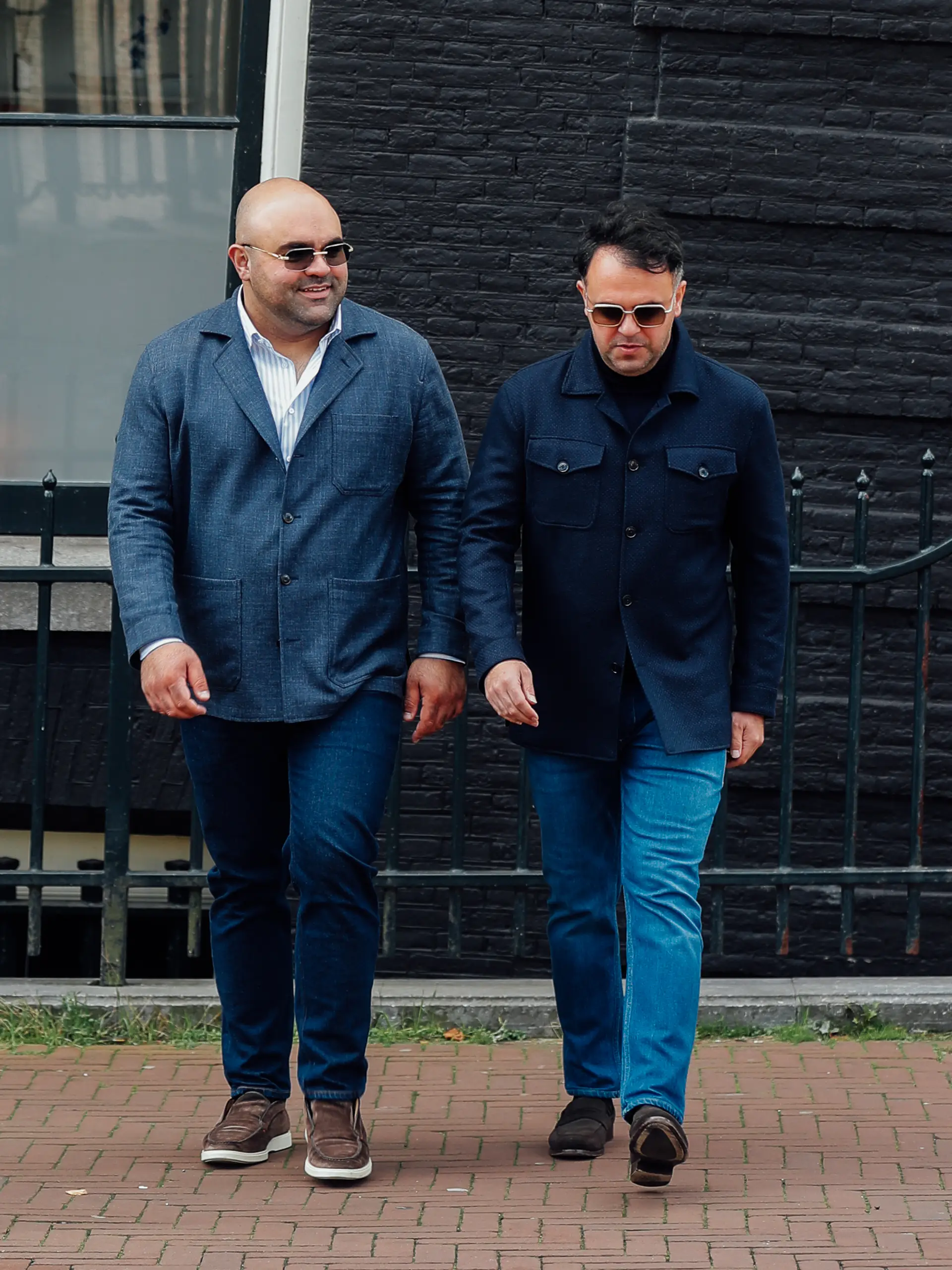 Amir en Arjan in blauwe maatjasjes met jeans en loafers, gekleed in een casual Ettemadis Fall Winter look.