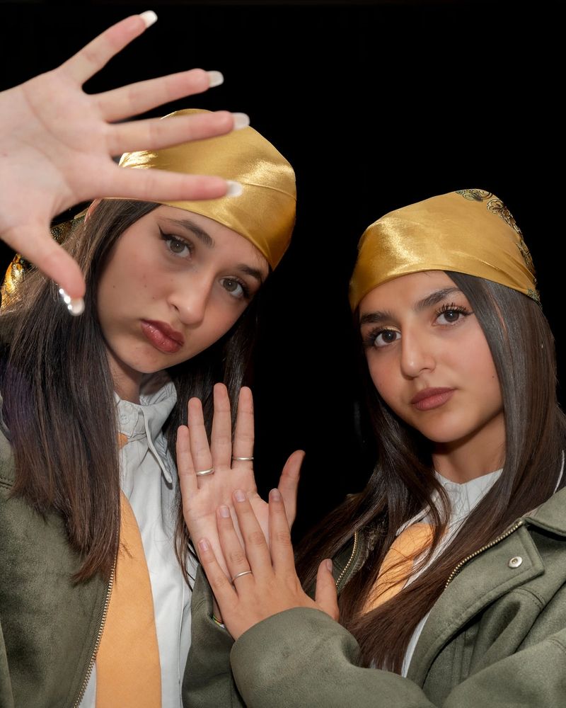 Due allieve di hip hop con le mani incrociate davanti al viso