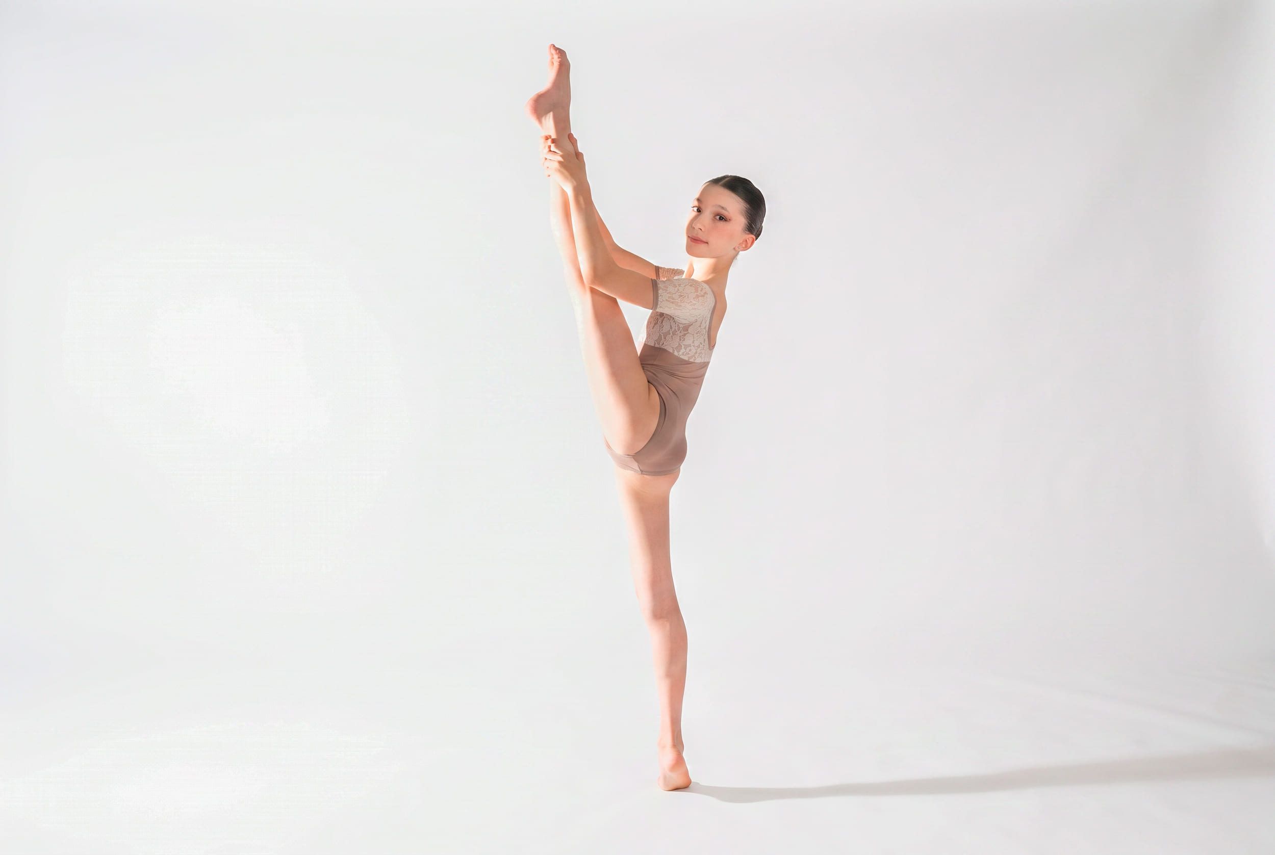 Allieva di danza classica in equilibrio con la gamba tesa verso l'alto