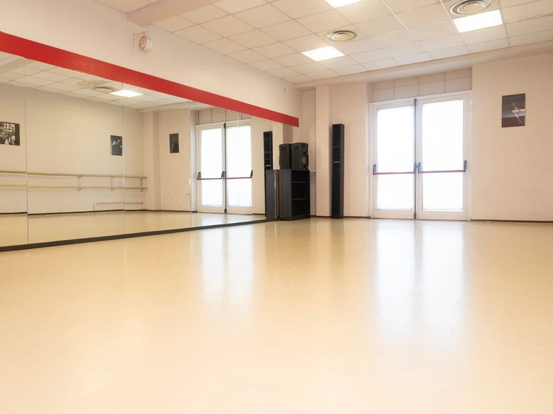 Sala 2: sala di danza con grandi finestre, molta luce naturale e sbarre alla parete