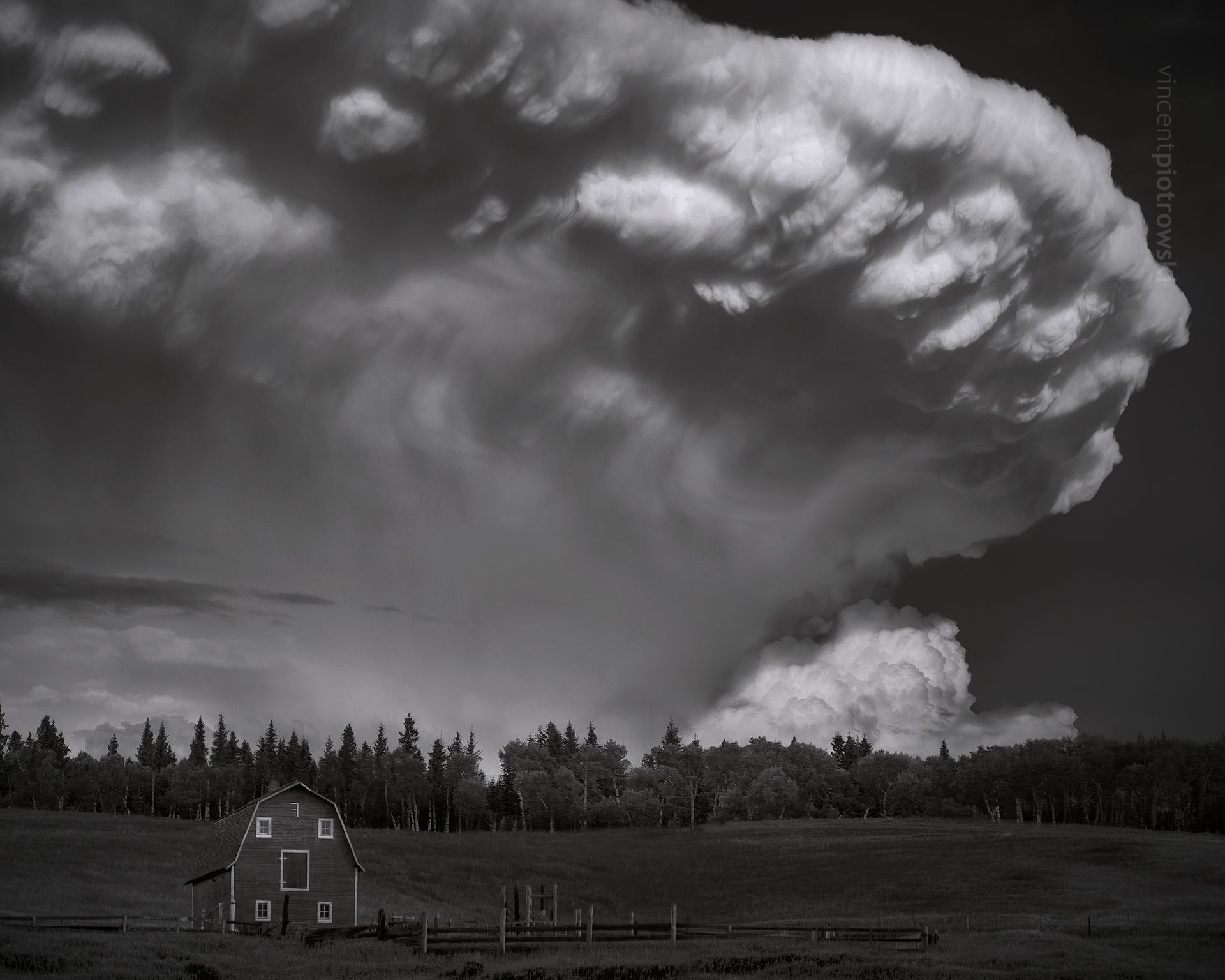 A massive mushroom shaped supercell over a barn in the foothills of Alberta