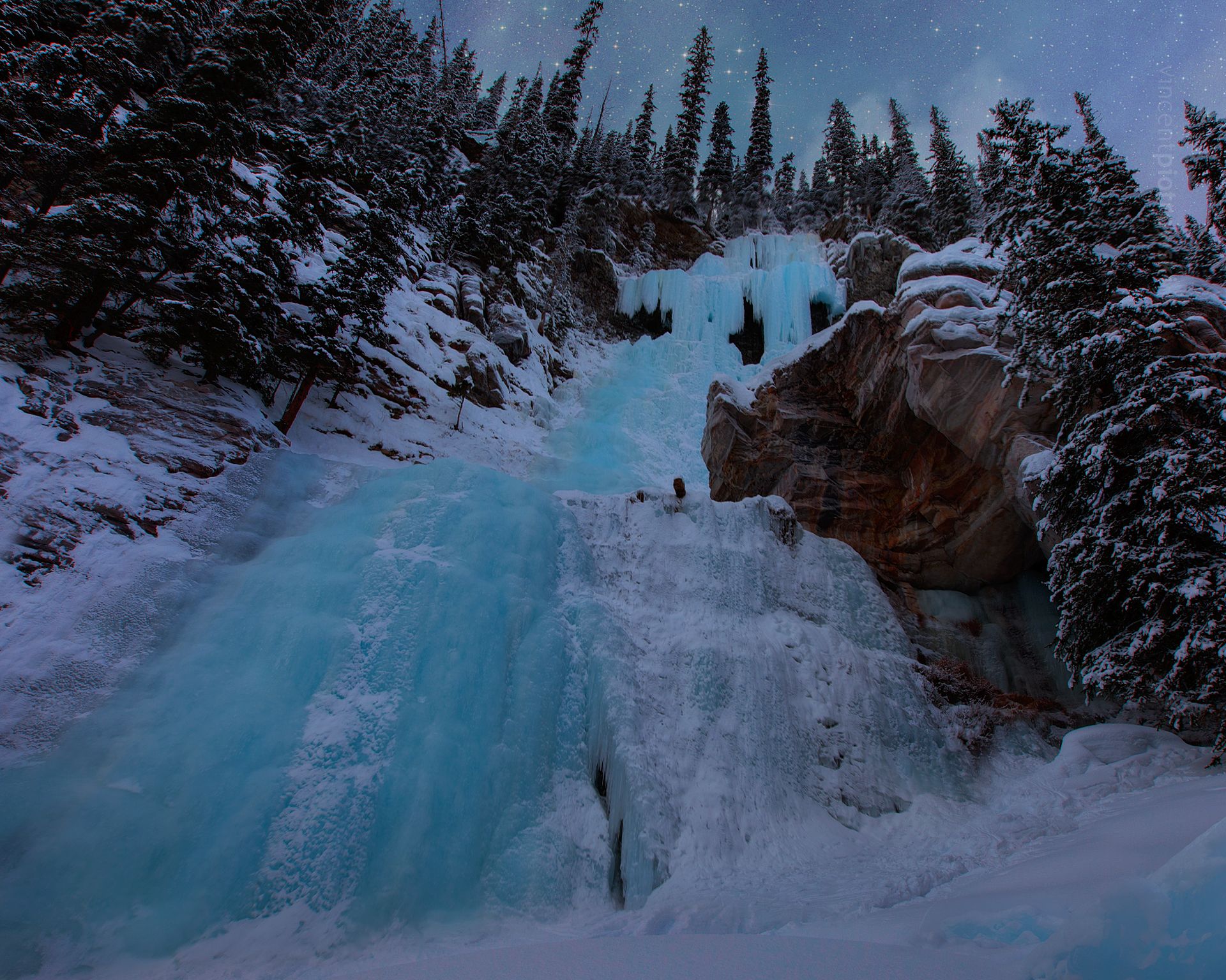 A frozen waterfall near Lake Louise at night