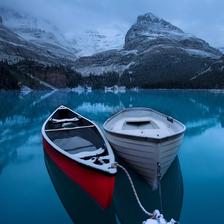 Two boats docked on a very calm Lake O'Hara in winter