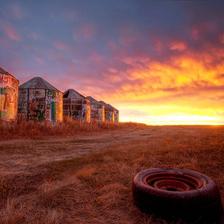 An intense sunrise behind old wooden grain silos on the prairies