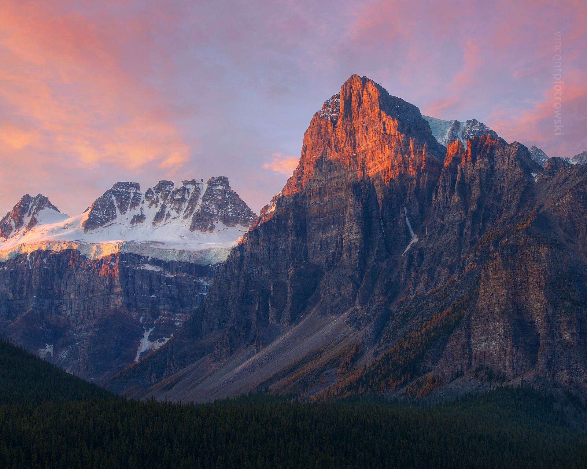 Tower of Babel getting hit with morning light above yellow larch trees
