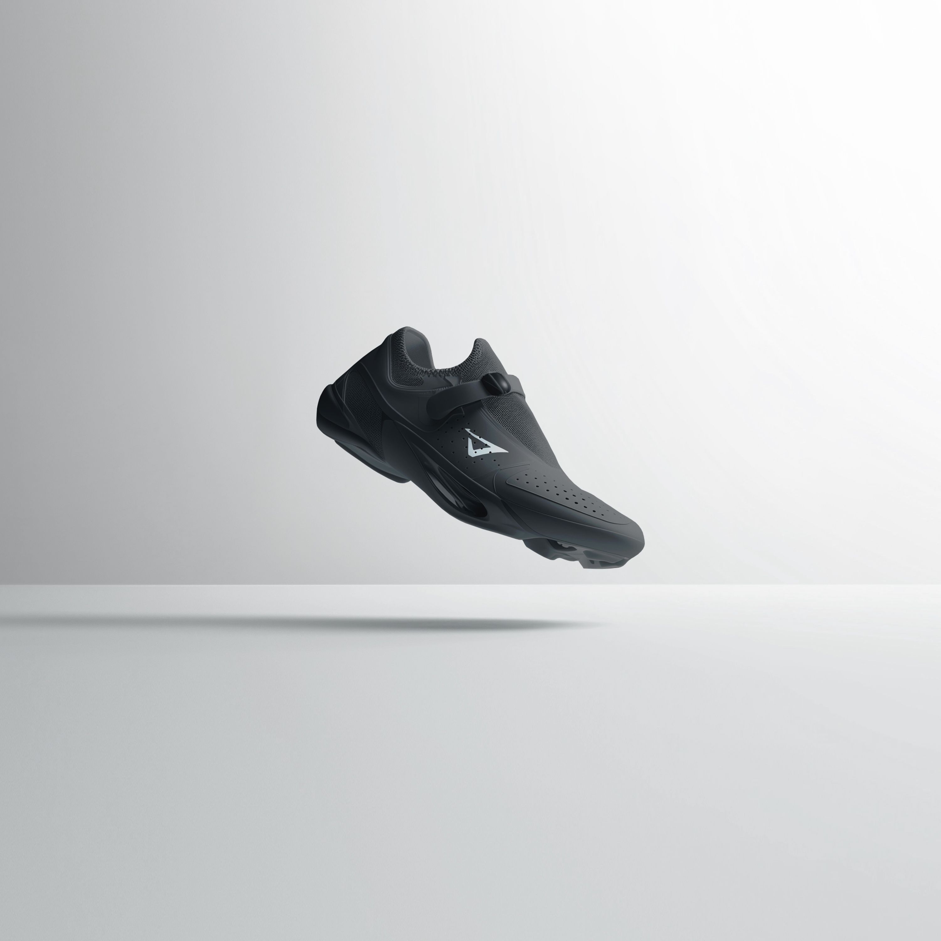 a black shoe is floating in the air on a white surface .