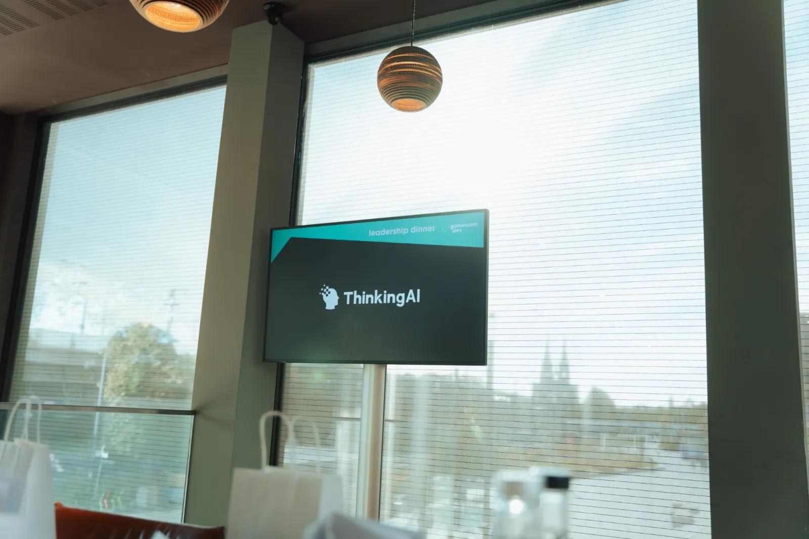 A ThinkingAI screen in the dining room with Cologne Cathedral through the window