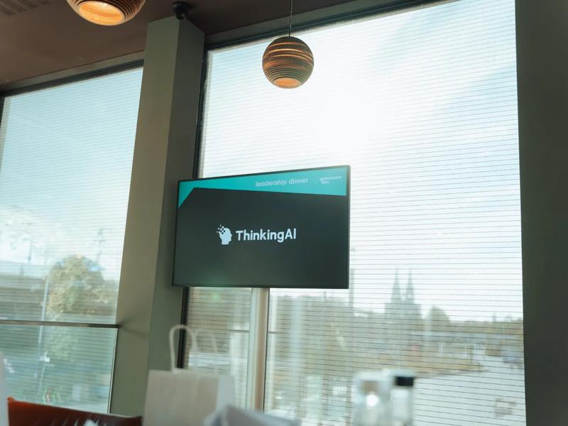 A ThinkingAI screen in the dining room with Cologne Cathedral through the window