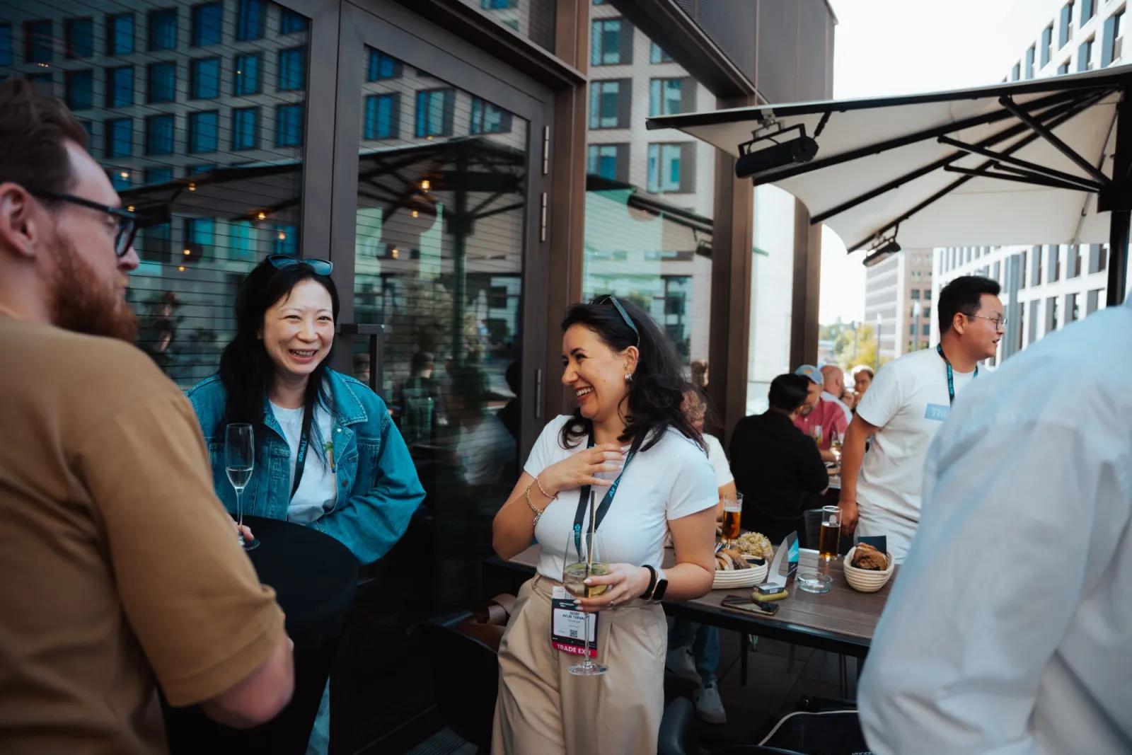 Guests with conference badges talking and laughing on the terrace