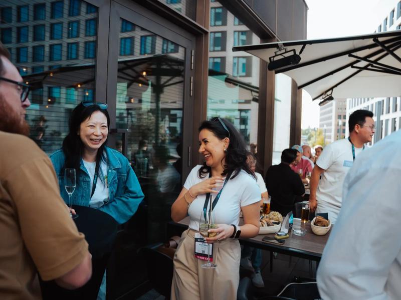 Guests with conference badges talking and laughing on the terrace