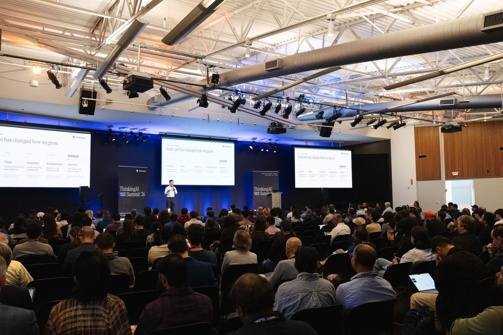 The full room at the Computer History Museum, seen from the back, with Chris Han on stage