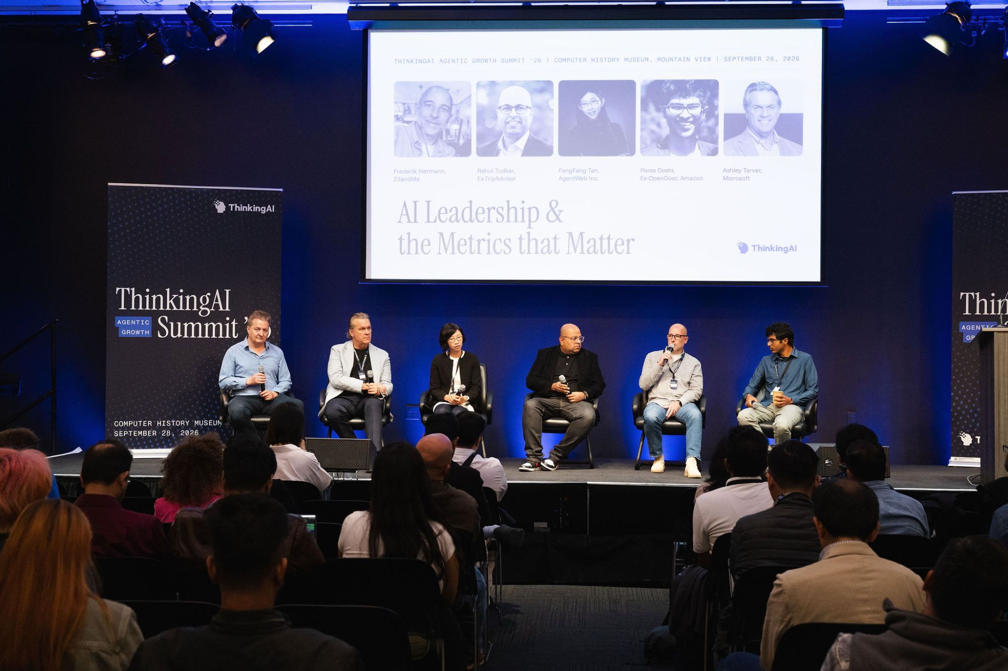 Five panelists and moderator Murray Newlands seated on stage