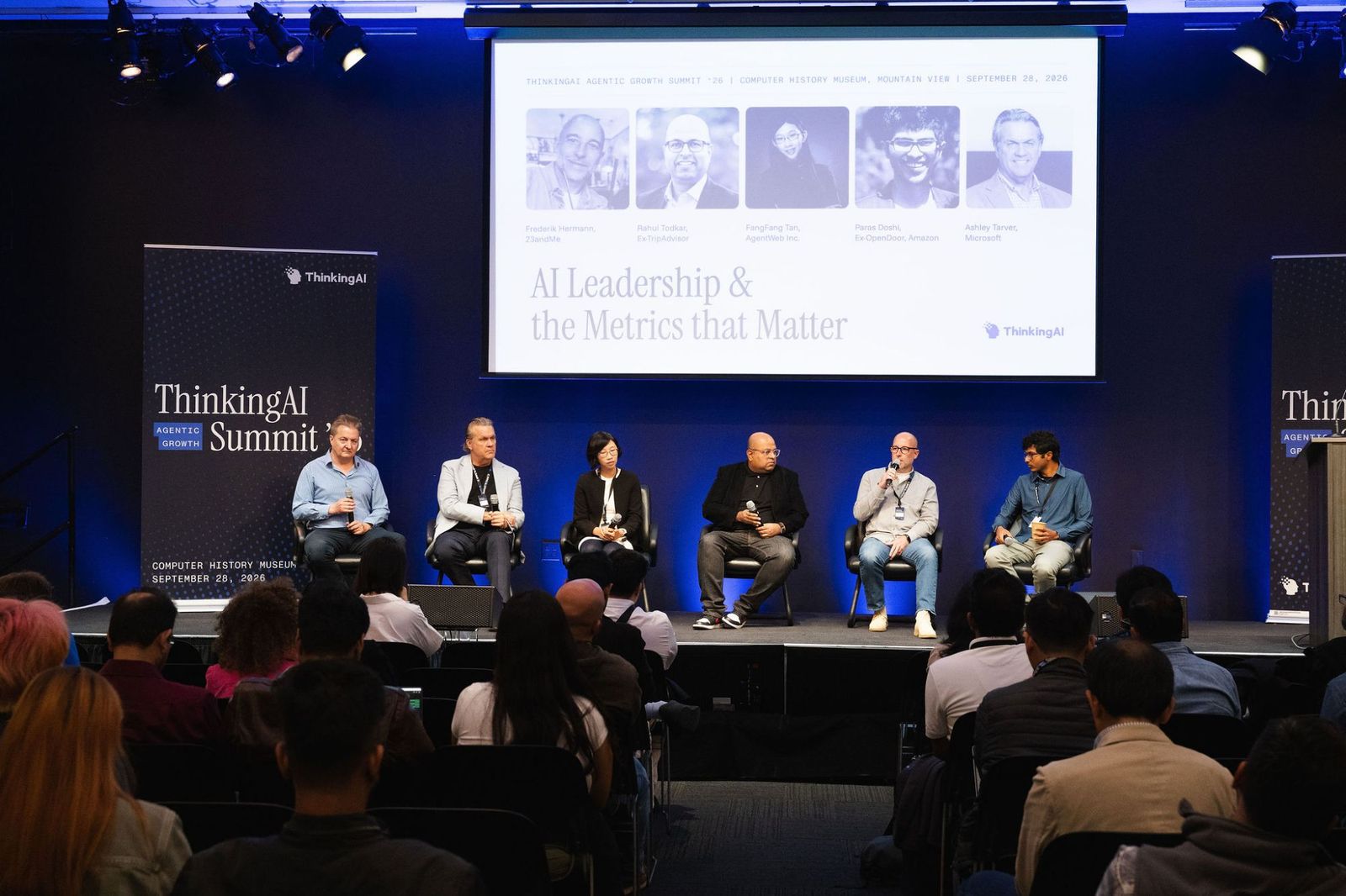 Five panelists and moderator Murray Newlands seated on stage