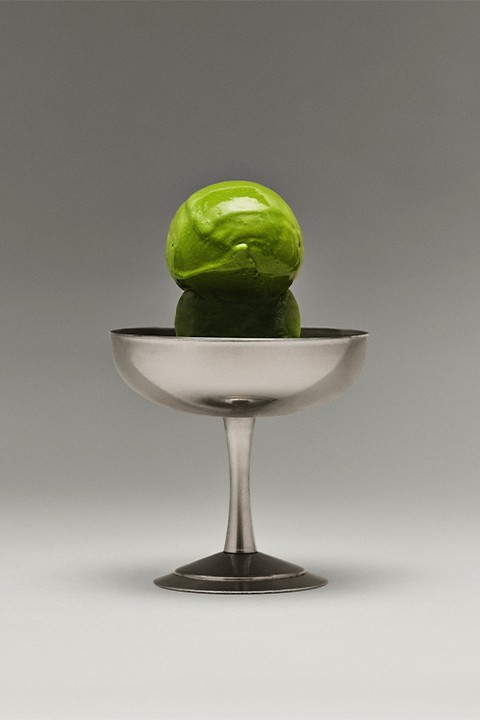 A bowl of two scoops of matcha ice cream.