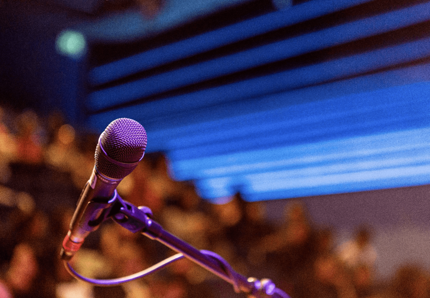 Microphone on stage with blurred audience in the background