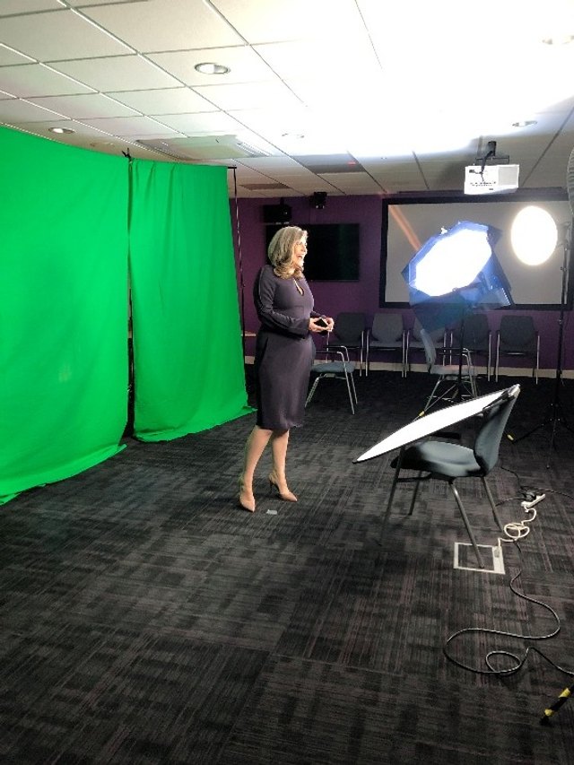 Louise Hosking beside a green-screen recording setup