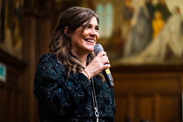 Louise Hosking speaking into a microphone at an event