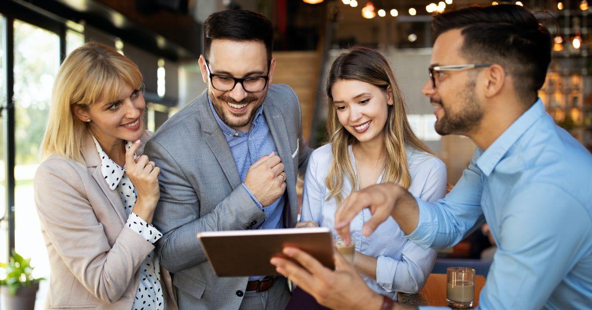 Team bespricht zufrieden Ergebnisse auf Tablet – Symbolbild für erfolgreiche SAP SuccessFactors Employee Central Implementierung