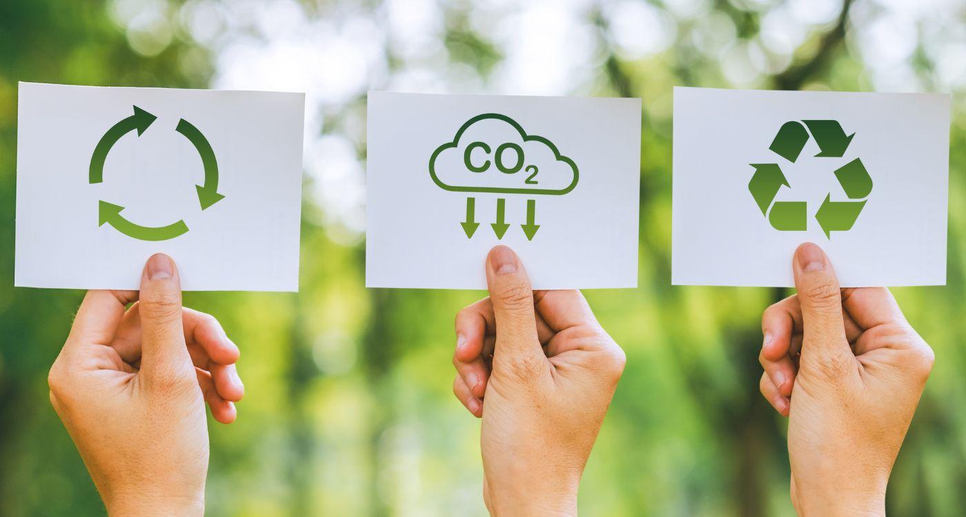 Hände halten Symbole für Recycling, CO2-Reduktion und Nachhaltigkeit – HR als Treiber für einen kleineren CO2-Fußabdruck im Unternehmen