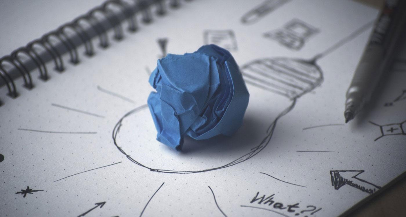 Zerknülltes blaues Papier symbolisiert Idee auf gezeichneter Glühbirne – Sinnbild für Werttreiberbaum-Planung in SAP Analytics Cloud