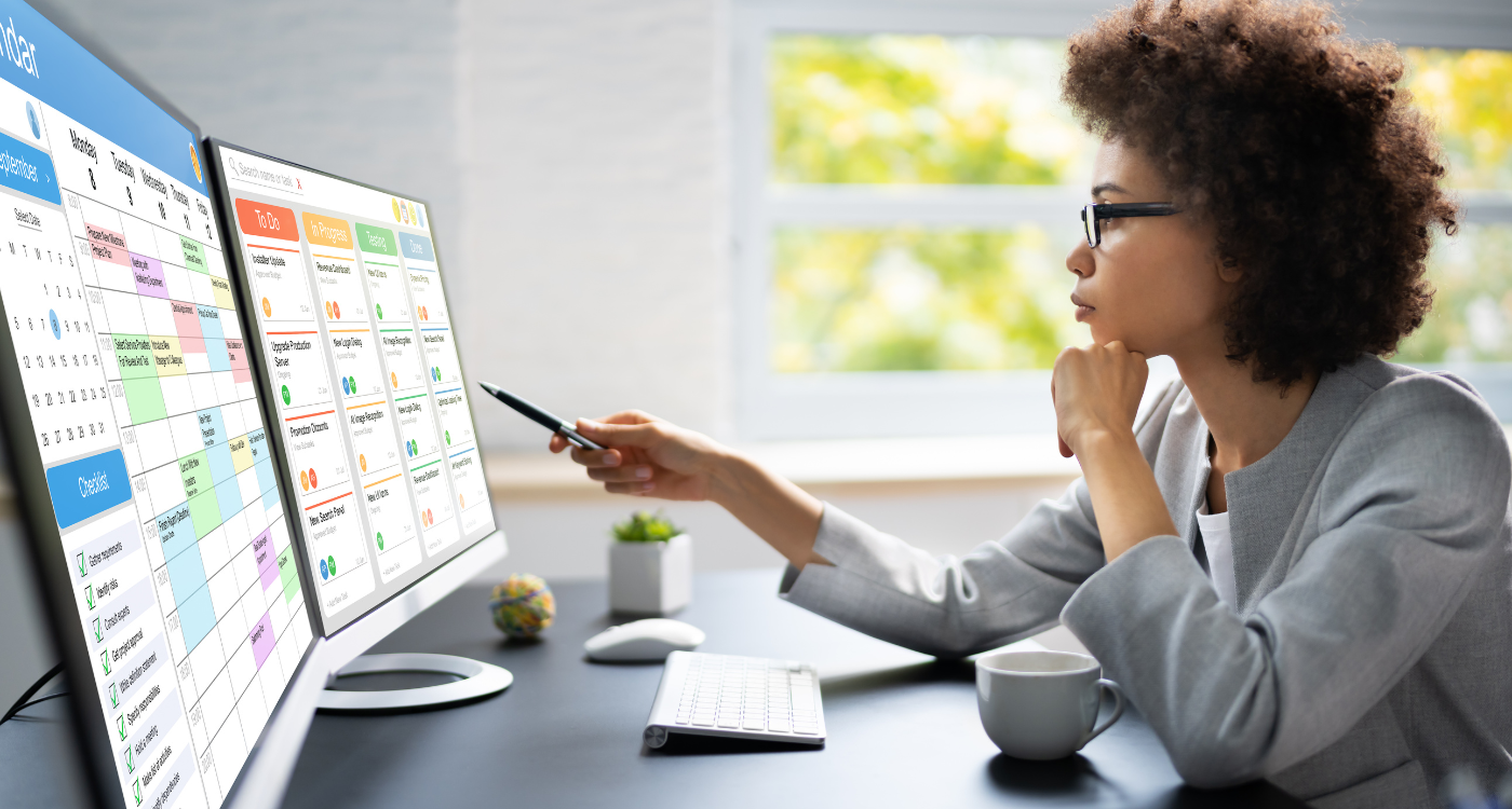 Mitarbeiterin analysiert Kalender und Aufgaben-Dashboard am Bildschirm – Symbolbild für effizientes Time Tracking und Workforce Management
