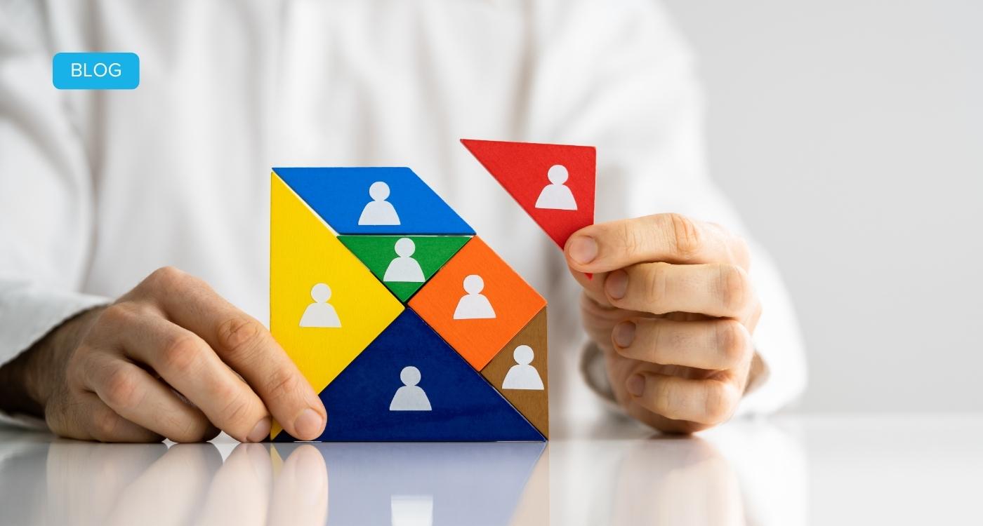 Hand fügt farbiges Puzzleteil mit Personensymbol hinzu – Symbolbild für erfolgreiches HR Change Management