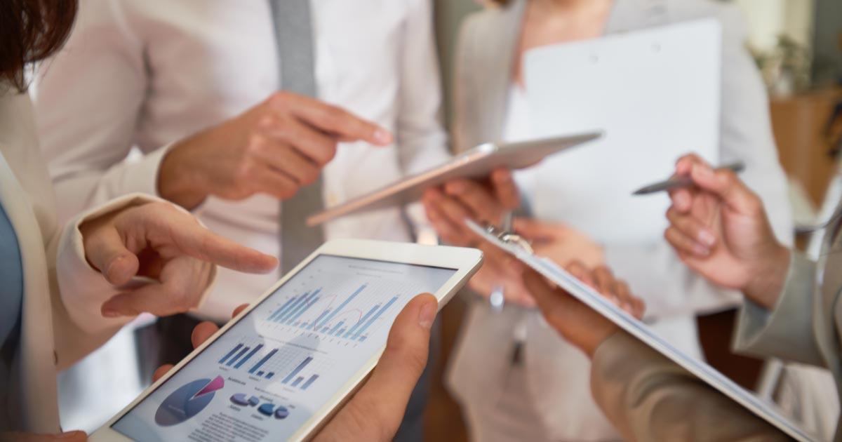 Team bespricht Diagramme auf Tablet und Klemmbrett – Symbolbild für Personalplanung mit SAP Analytics Cloud