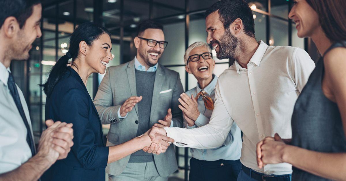 Team feiert erfolgreichen Handschlag zwischen Partnern – Symbolbild für den neuen SAP-Partnerstatus