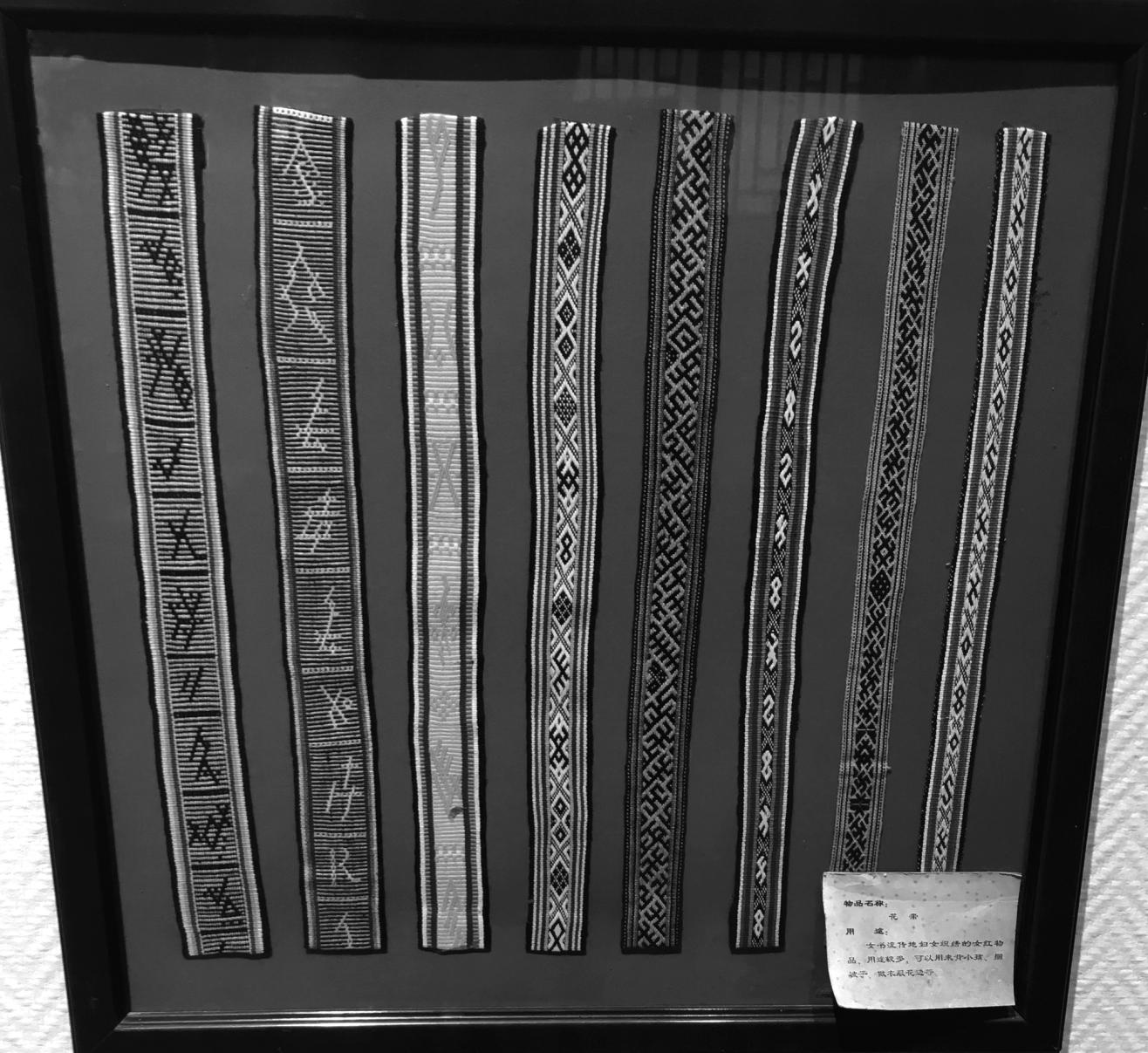 Frame with eight silk belts with Nüshu characters woven as part of the pattern.