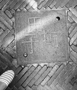 Photo of a carved stone decoration on the ground.