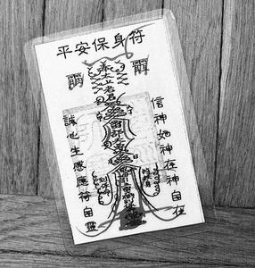 Photo of a yellow card with Buddhist protection spells.