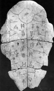 Picture in black and white of a tortoise shell with Oracle Bone script inscriptions.