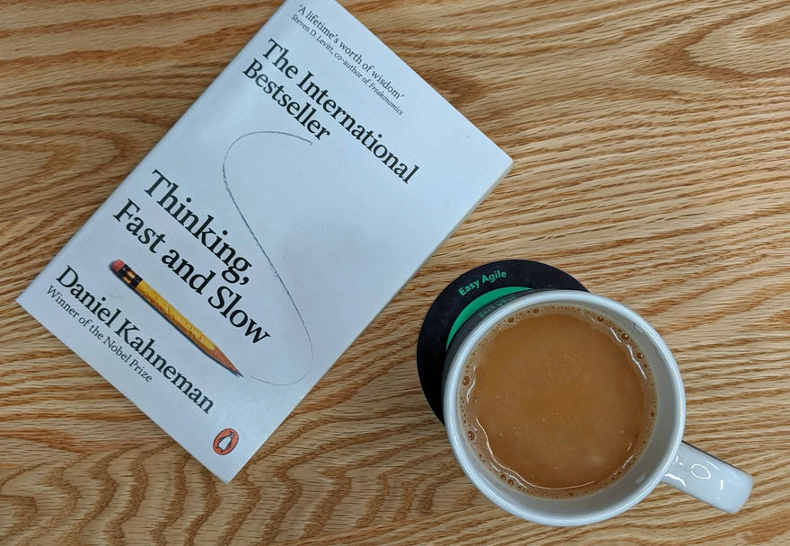 Copy of Daniel Kahneman's book 'Thinking, Fast and Slow' and coffee cup on table