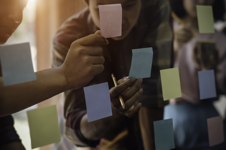affinity mapping: men looking at the sticky notes