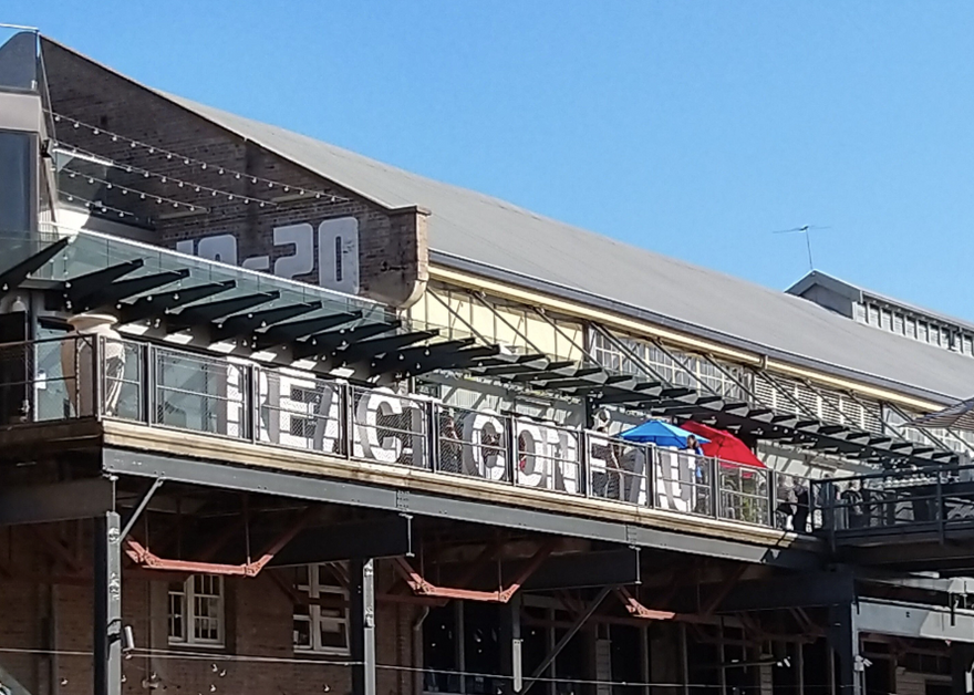 A building with objects in the shape of letters spelling 'React Conf' positioned on a balcony. 