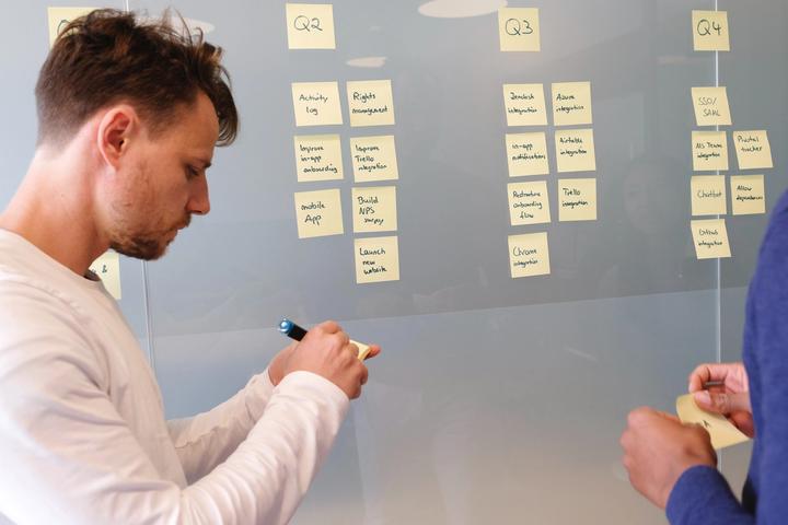 Jira project management: Group of people looking at sticky notes