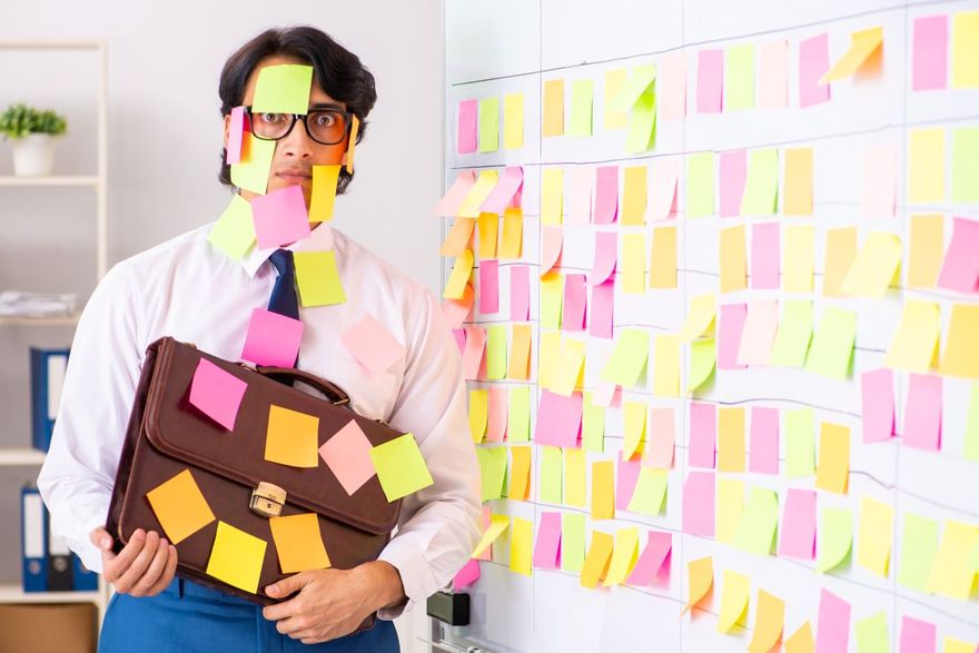 Businessman holding a briefcase, covered in sticky notes