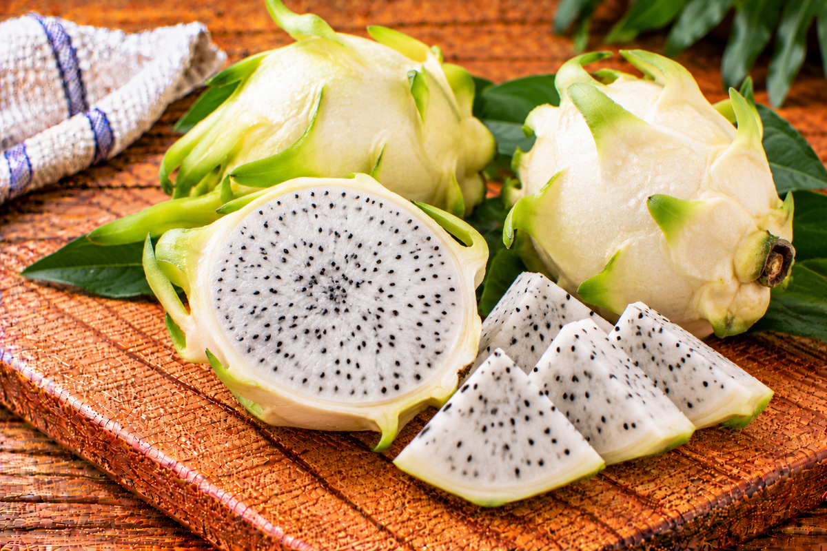 White dragon fruit with pink skin and pale flesh dotted with black seeds
