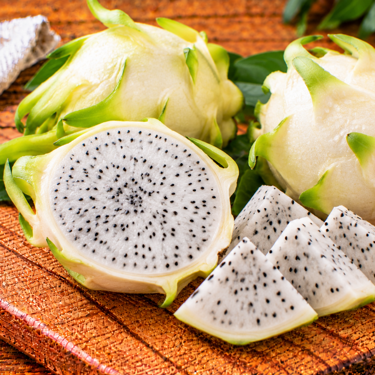 White dragon fruit with pink skin and pale flesh dotted with black seeds