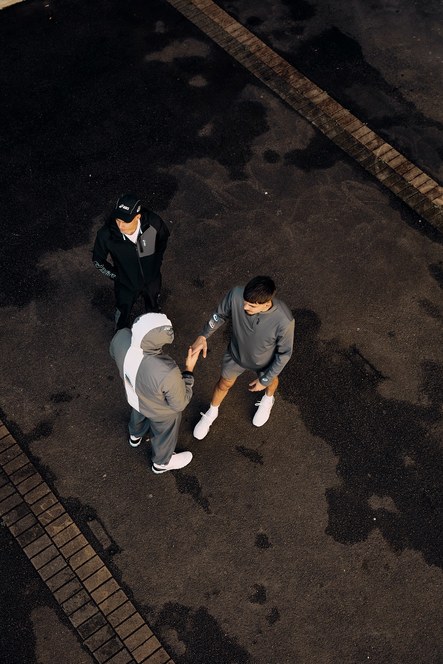 Two friends greeting each other on the street in ASICS GEL-Quantum 360 shoes