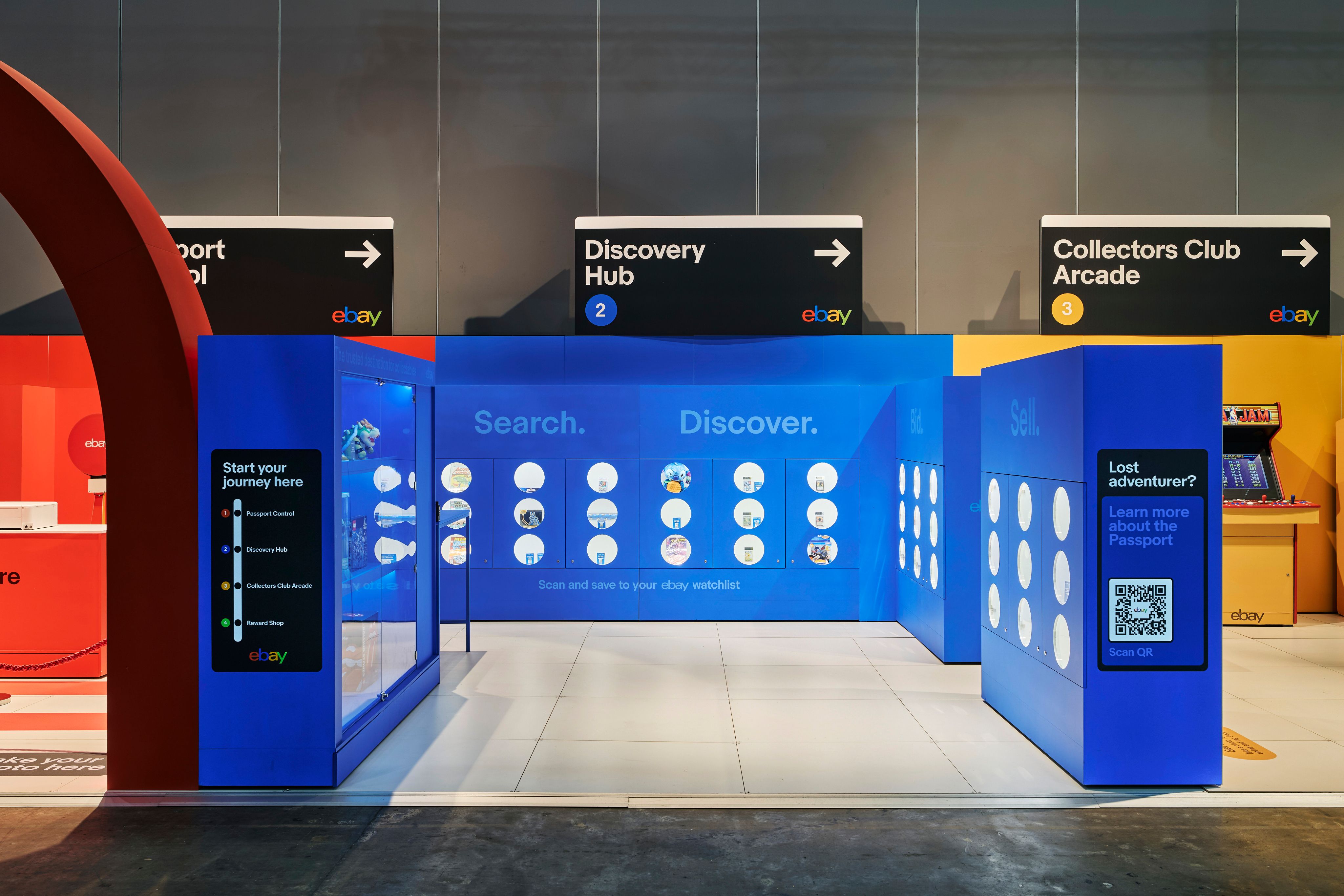 Interior view of the eBay Collectors Club activation at PAX with NYC Subway-style signage for ‘Passport Refill’, ‘Discovery Hub’ and ‘Collectors Club Arcade’ above interactive blue display zones