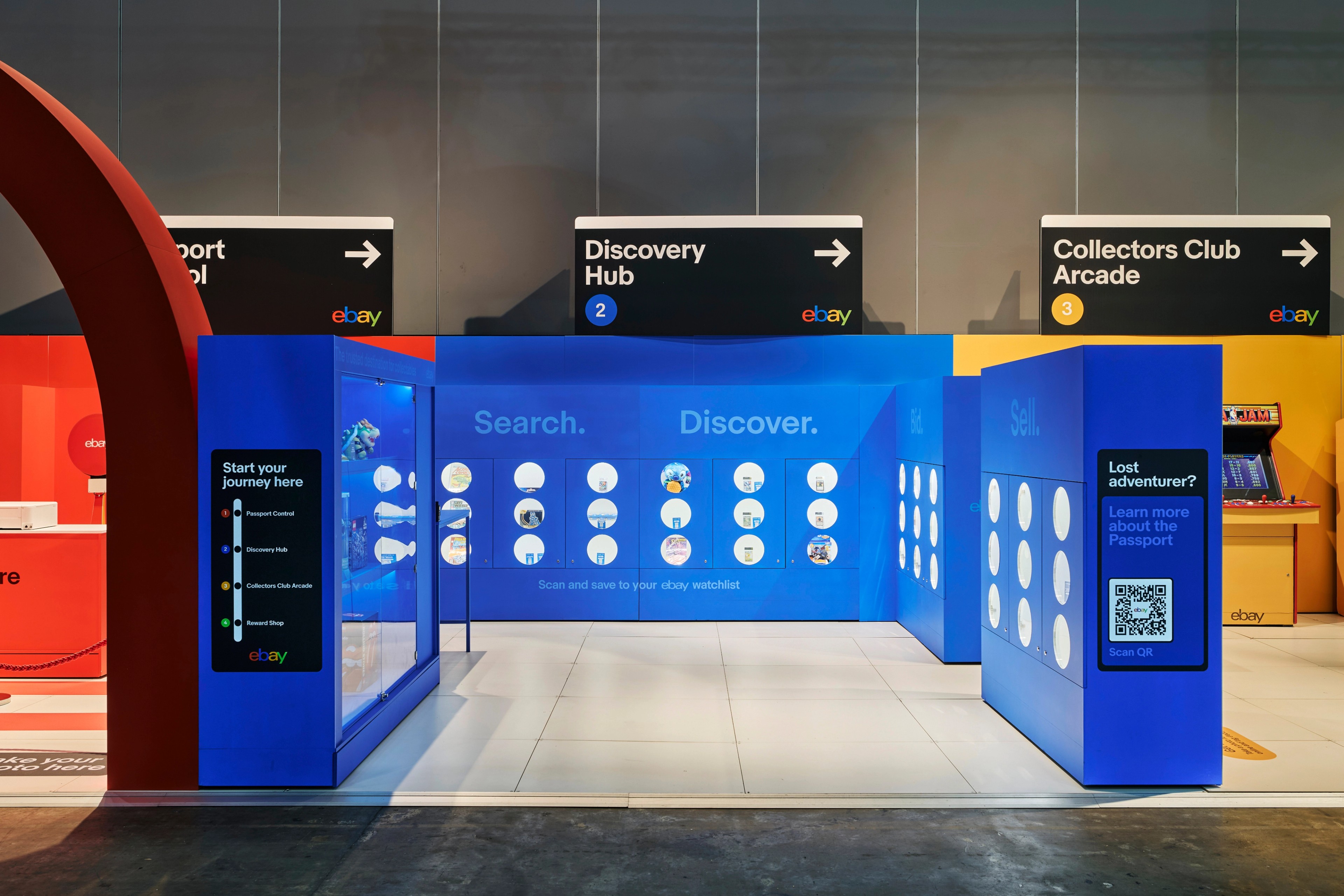 Interior view of the eBay Collectors Club activation at PAX with NYC Subway-style signage for ‘Passport Refill’, ‘Discovery Hub’ and ‘Collectors Club Arcade’ above interactive blue display zones