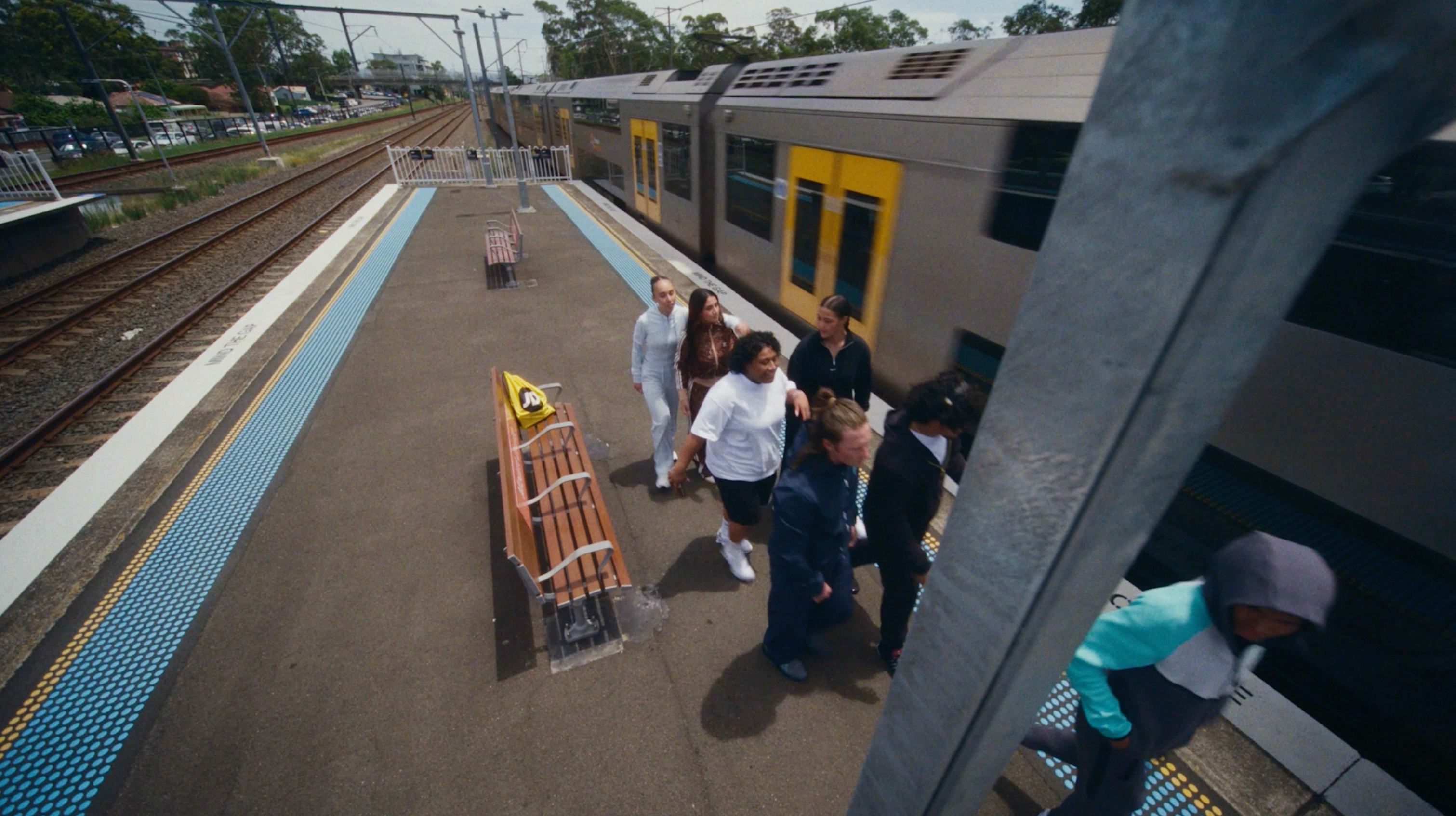 Young people gathered on a Sydney train station platform in streetwear