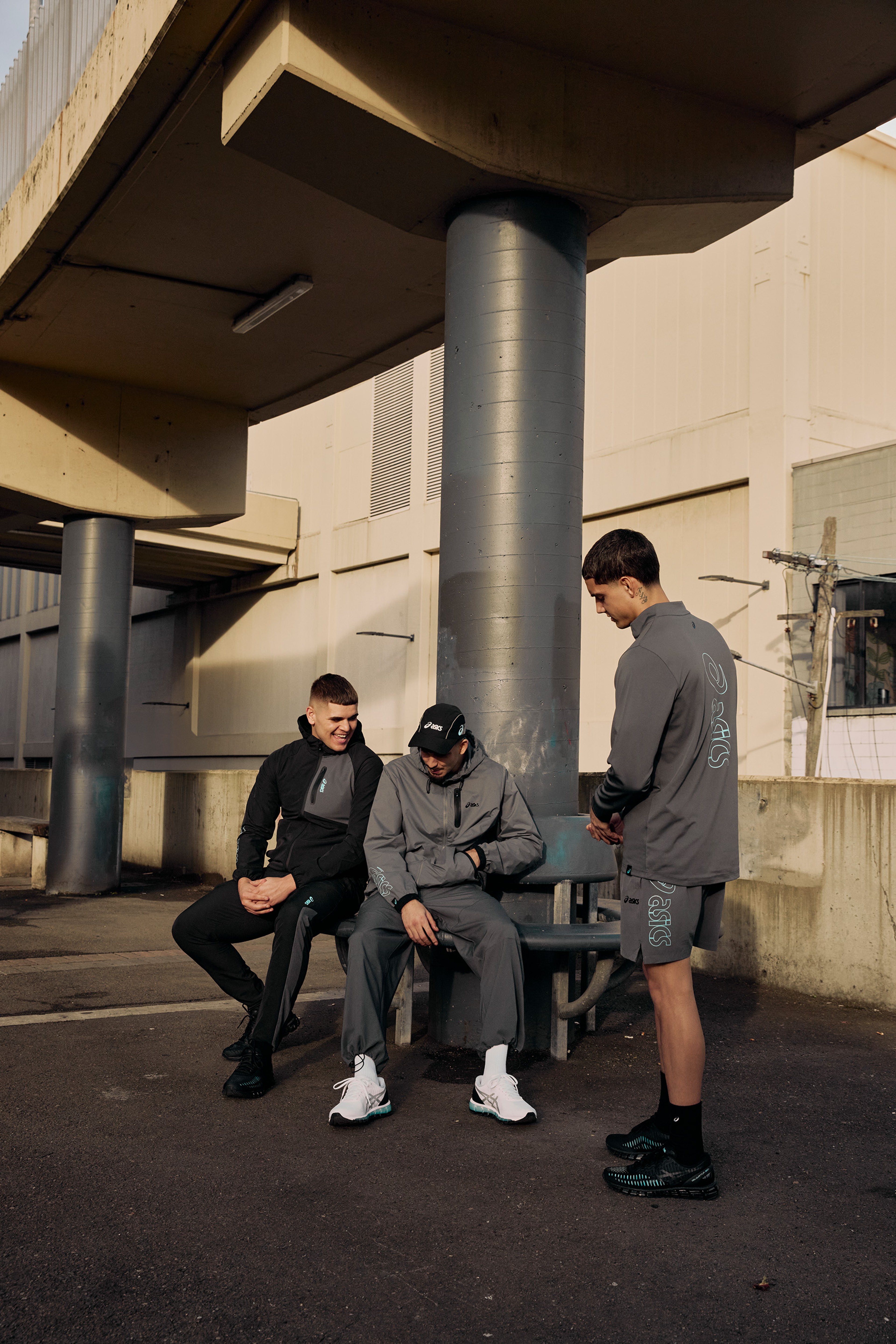 Group of friends in ASICS GEL-Quantum 360 shoes standing against a concrete pillar